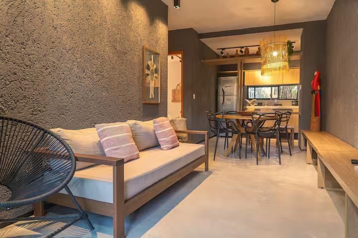 Sala com sofá, tapete e vista para a cozinha