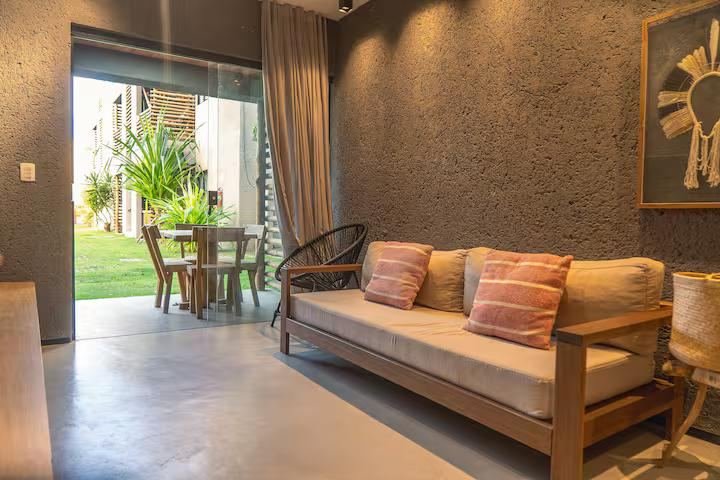 Sala de estar com sofá e portas de vidro para a área externa