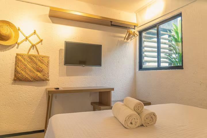 Suíte com cama de casal e televisão